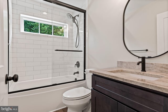 full bathroom featuring vanity, toilet, and bath / shower combo with glass door