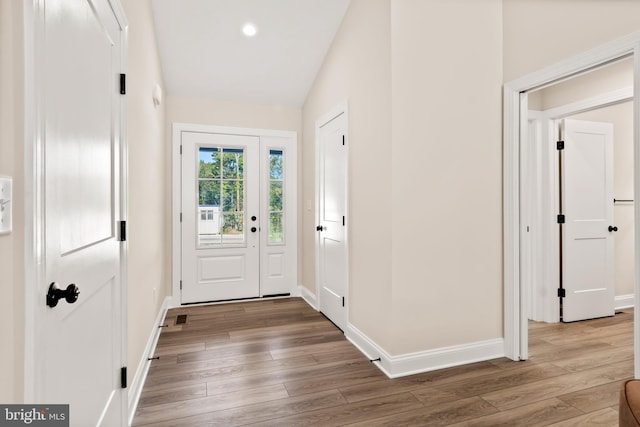 entryway featuring hardwood / wood-style flooring and vaulted ceiling