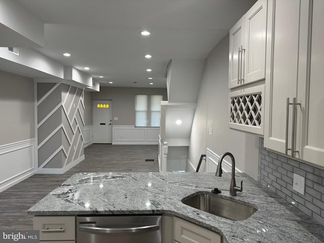 kitchen featuring tasteful backsplash, sink, light stone counters, and white cabinets