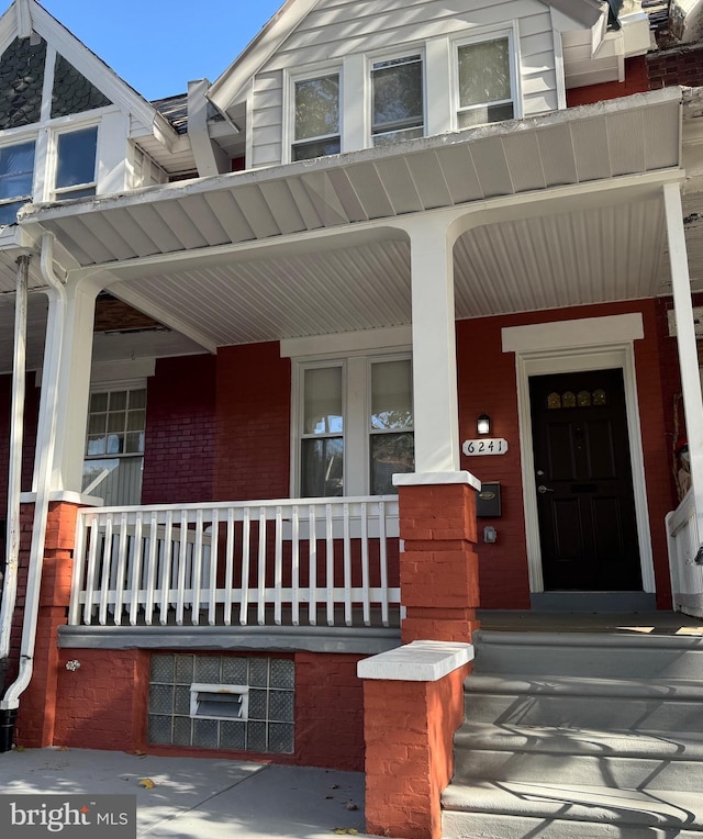 view of exterior entry featuring covered porch