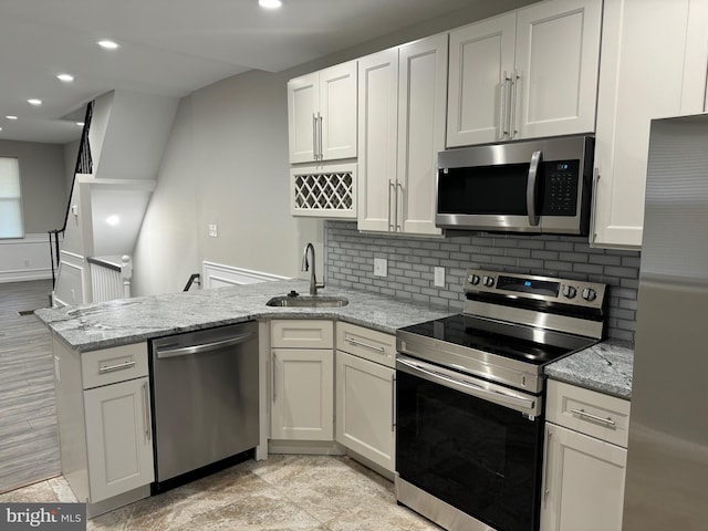 kitchen featuring white cabinets, light stone countertops, sink, and appliances with stainless steel finishes