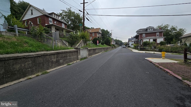 view of road featuring a residential view and curbs