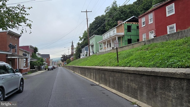 view of road with street lighting, a residential view, and curbs