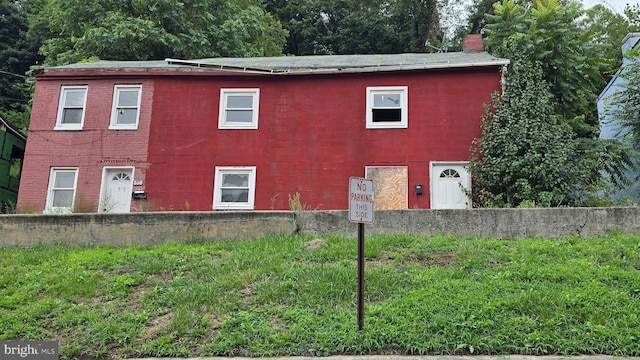 view of side of home with concrete block siding and a chimney