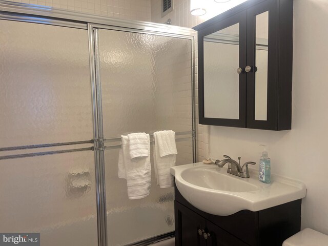 bathroom with vanity and enclosed tub / shower combo