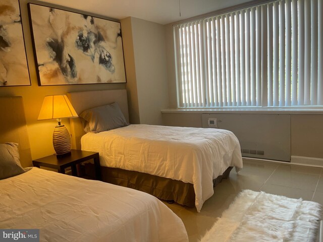 bedroom with light tile patterned floors and multiple windows