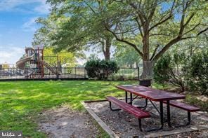 view of home's community featuring a playground and a lawn