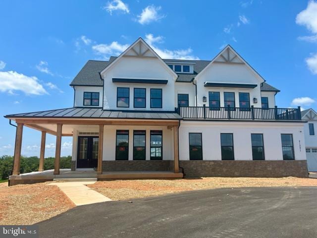 view of front of house featuring a standing seam roof, covered porch, and metal roof