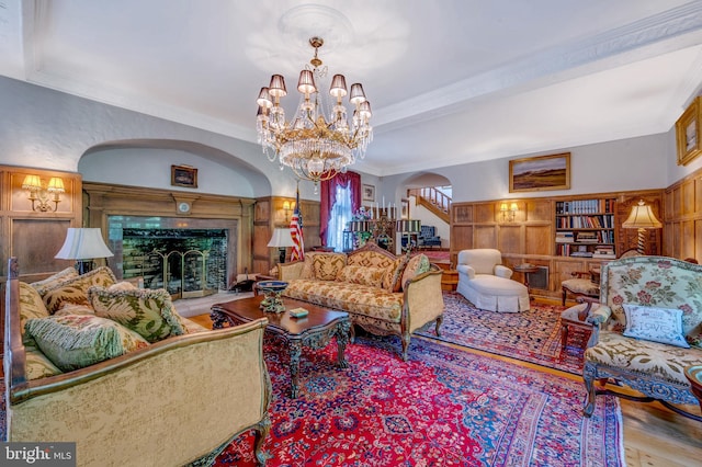 living room with ornamental molding, arched walkways, and a fireplace