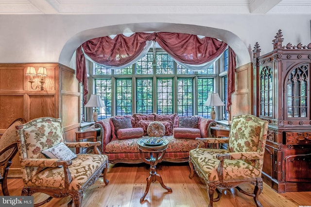 living area with plenty of natural light, hardwood / wood-style flooring, and crown molding