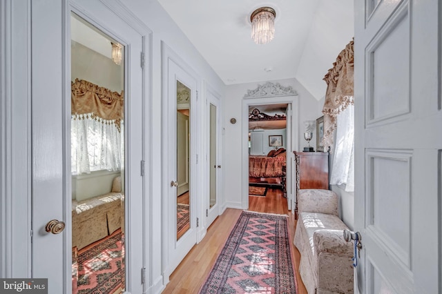 interior space featuring lofted ceiling, an inviting chandelier, and light wood-style floors