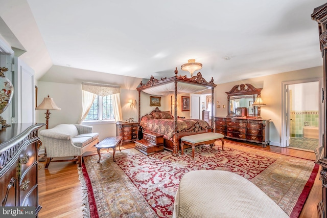 bedroom featuring light wood-style floors and ensuite bathroom