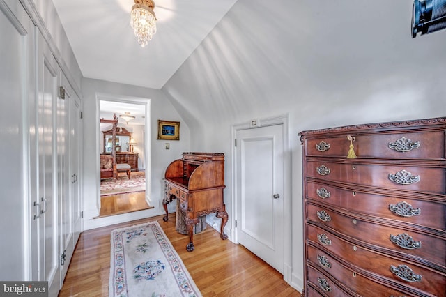 entryway featuring lofted ceiling, light wood-style floors, and a chandelier