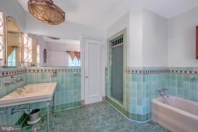 full bathroom with a bath, a wainscoted wall, a shower stall, and tile walls