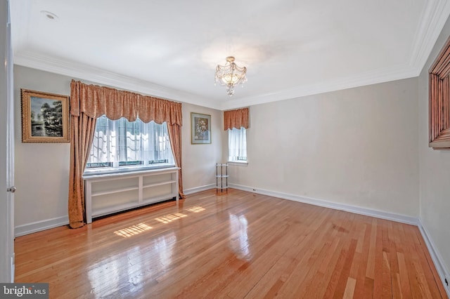 interior space featuring ornamental molding, baseboards, an inviting chandelier, and hardwood / wood-style flooring