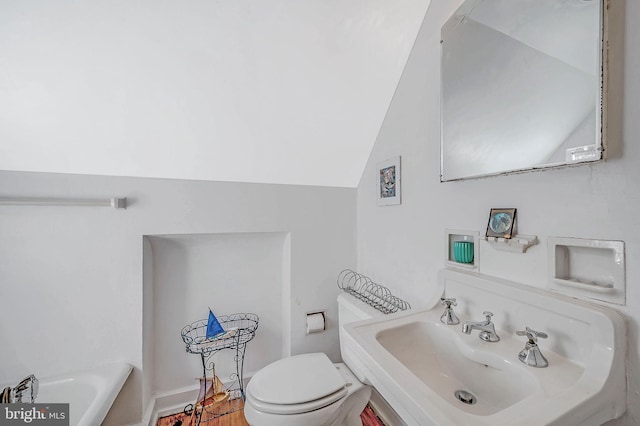 bathroom featuring lofted ceiling, a sink, and toilet