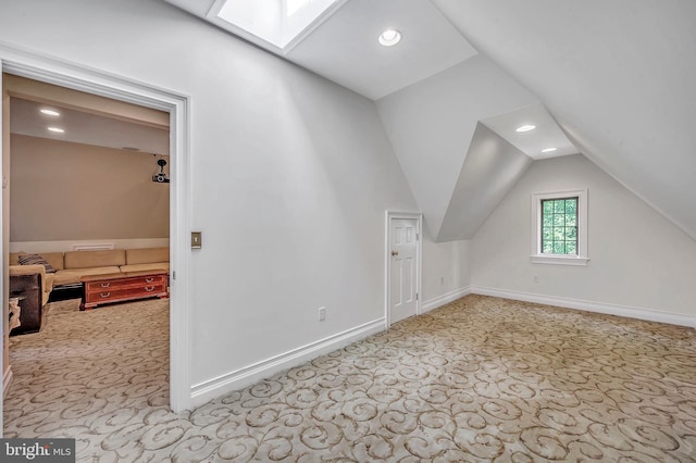 bonus room with carpet floors, vaulted ceiling with skylight, recessed lighting, and baseboards