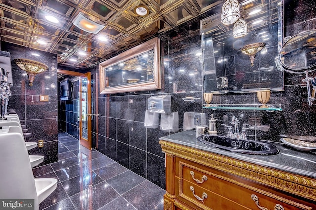 bathroom with an ornate ceiling, tile walls, granite finish floor, a bidet, and vanity