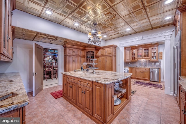 kitchen featuring a kitchen island with sink, open shelves, tasteful backsplash, brown cabinetry, and an ornate ceiling