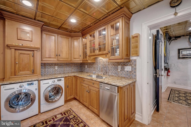 laundry area with laundry area, separate washer and dryer, a sink, baseboards, and an ornate ceiling