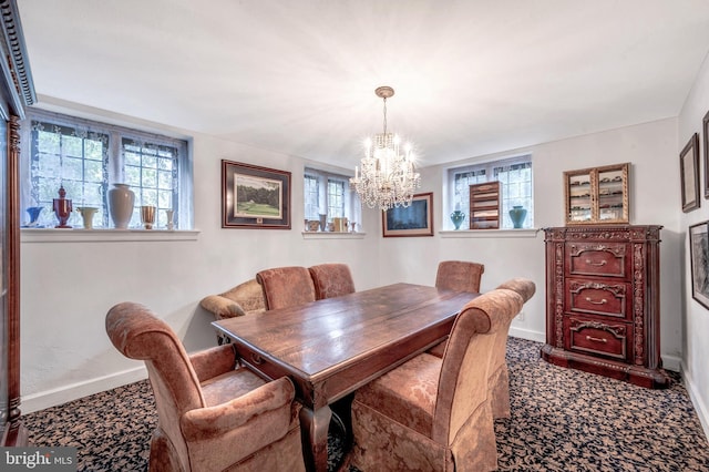 dining room with a healthy amount of sunlight, a notable chandelier, baseboards, and carpet flooring