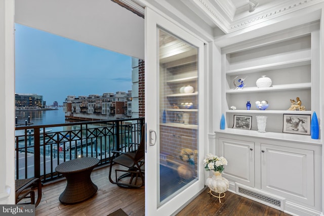 balcony featuring a view of city, visible vents, and a water view