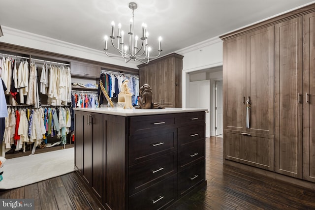 spacious closet with dark hardwood / wood-style flooring and a notable chandelier