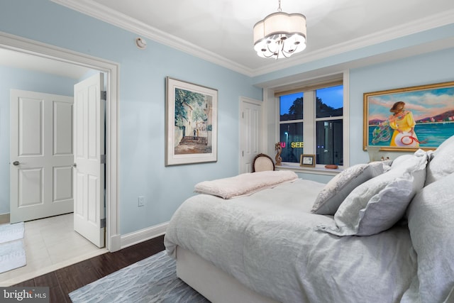 bedroom with ornamental molding, a notable chandelier, and hardwood / wood-style floors