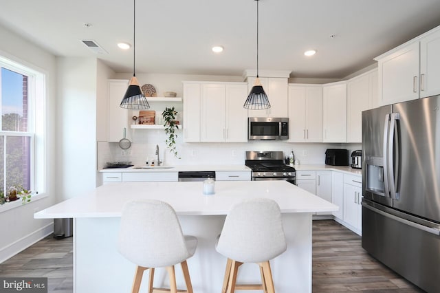 kitchen featuring a center island, stainless steel appliances, and white cabinets