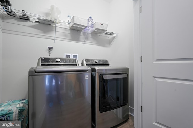 clothes washing area featuring washer and dryer and hardwood / wood-style floors