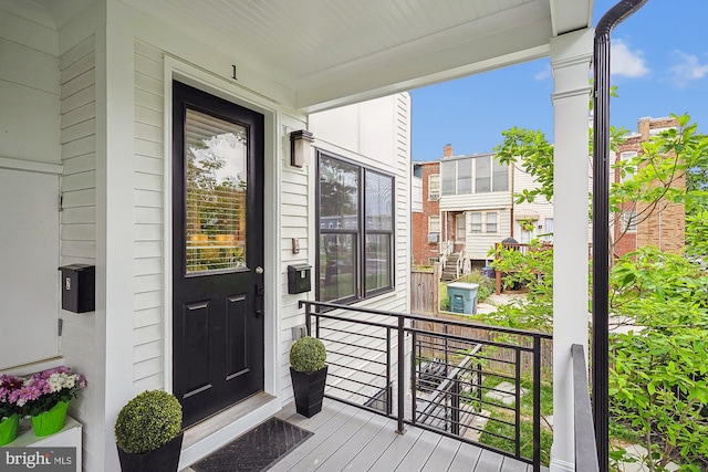 view of exterior entry featuring covered porch