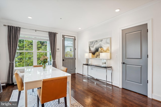 dining area with ornamental molding and dark hardwood / wood-style floors