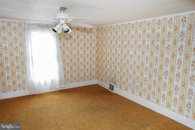 spare room featuring wallpapered walls, carpet, visible vents, and baseboards