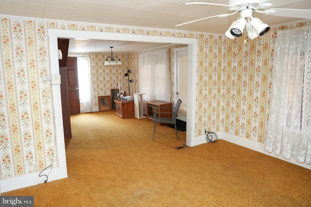 interior space featuring wallpapered walls, baseboards, ornamental molding, and a ceiling fan