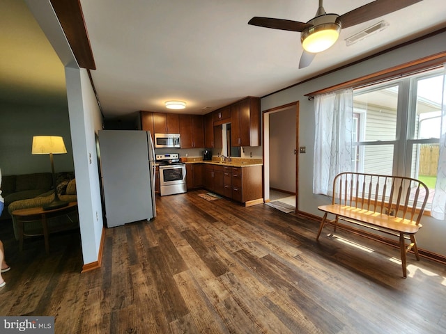 kitchen with stainless steel appliances, ceiling fan, and dark hardwood / wood-style floors