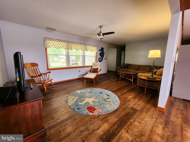 living area with ceiling fan and dark hardwood / wood-style flooring