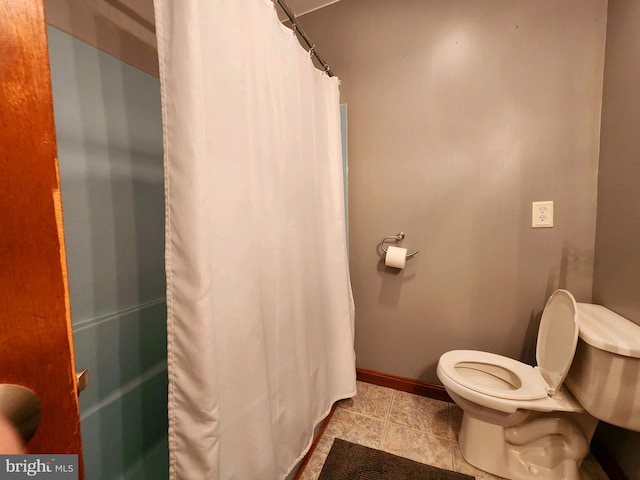 bathroom with tile patterned flooring, toilet, and walk in shower