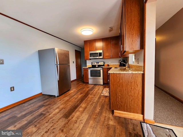 kitchen with stainless steel appliances, sink, and dark hardwood / wood-style flooring