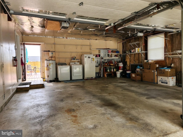 garage featuring separate washer and dryer, water heater, and fridge