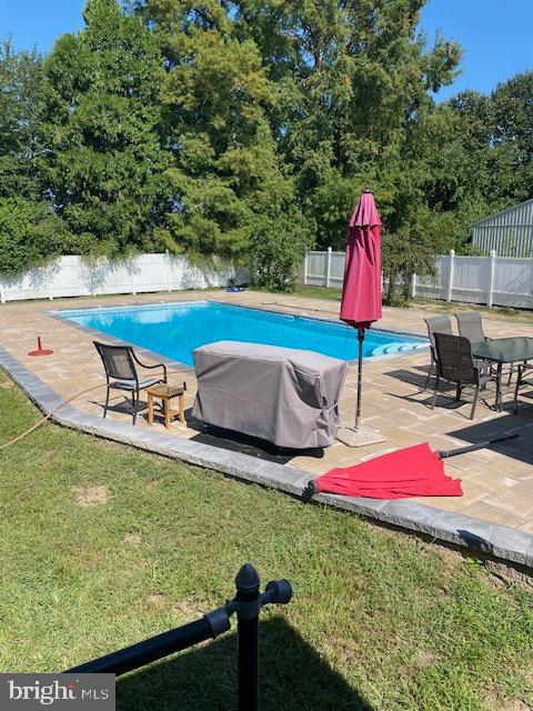 view of pool with a yard, a grill, and a patio