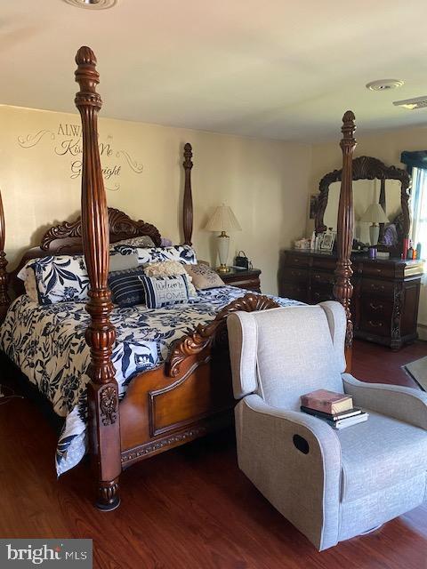 bedroom with dark hardwood / wood-style flooring