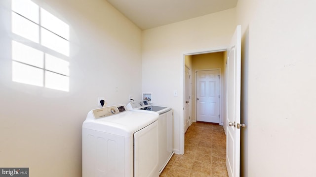 clothes washing area featuring laundry area, washing machine and dryer, and baseboards