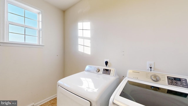 washroom with laundry area, washing machine and clothes dryer, a wealth of natural light, and baseboards