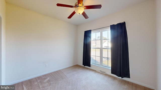 unfurnished room featuring a ceiling fan, carpet, visible vents, and baseboards