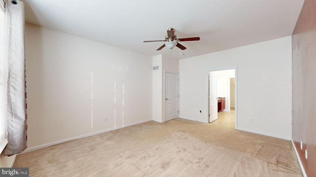 unfurnished bedroom featuring light carpet, baseboards, visible vents, a ceiling fan, and connected bathroom