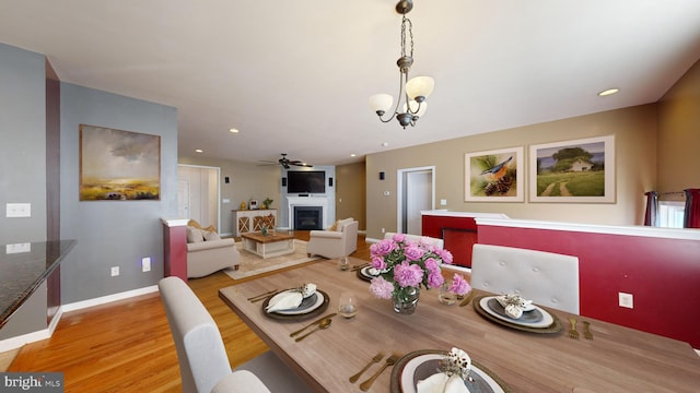 dining space with baseboards, light wood-type flooring, a fireplace, and recessed lighting