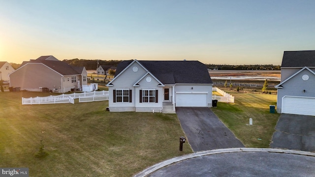 view of front facade with driveway, a lawn, and fence