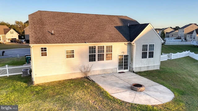 back of house featuring a yard, a fenced backyard, a fire pit, and a patio