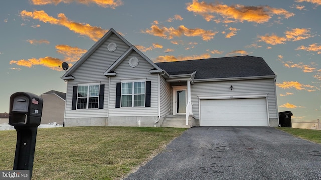 view of front of house featuring a garage, driveway, and a lawn