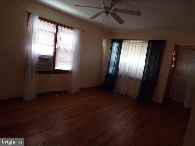 empty room with ceiling fan, dark hardwood / wood-style flooring, and a healthy amount of sunlight